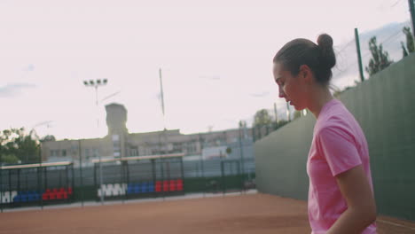 Tenis-Profesional-Determinado-Jugador-Deportivo-Chica-Golpeando-La-Raqueta-En-La-Pelota-En-La-Cancha-Roja-Profesional-Durante-El-Partido-Al-Aire-Libre-En-Cámara-Lenta